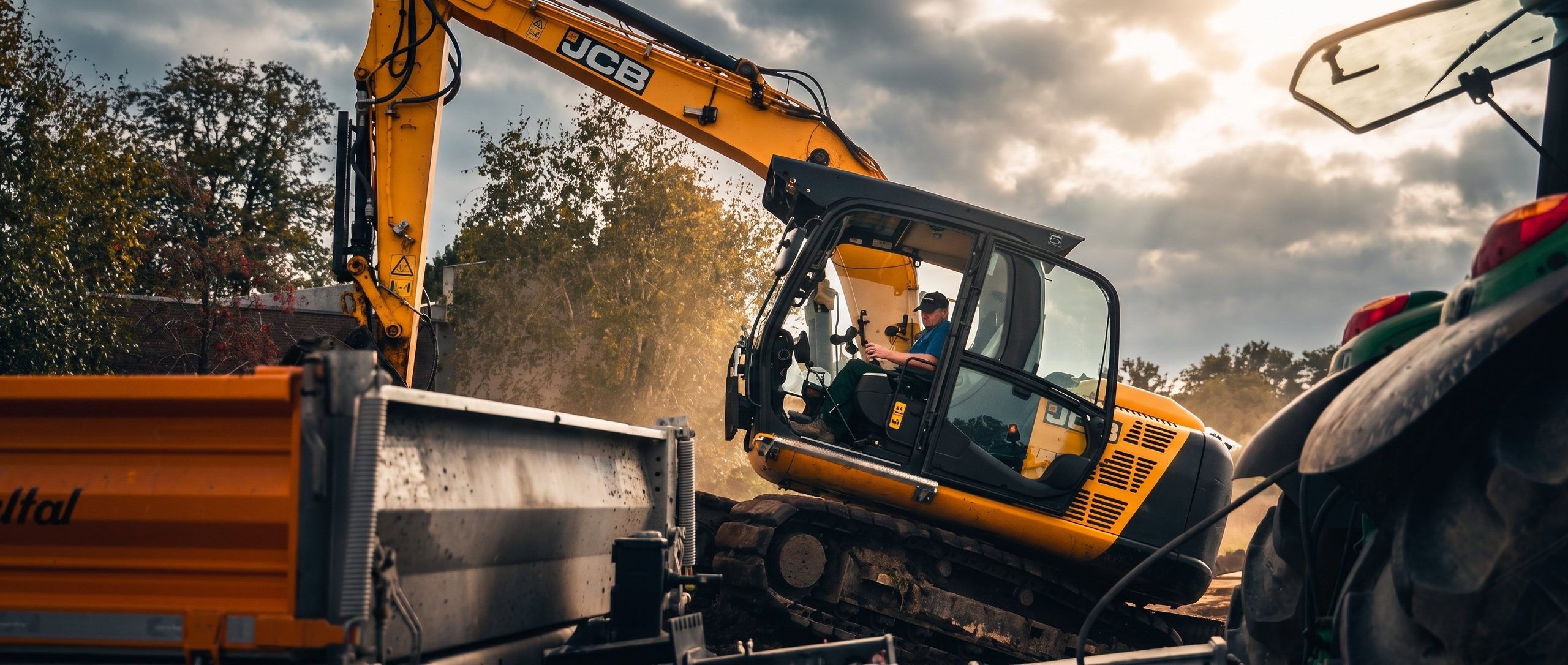 JCB-Bagger belädt einen Muldenkipper